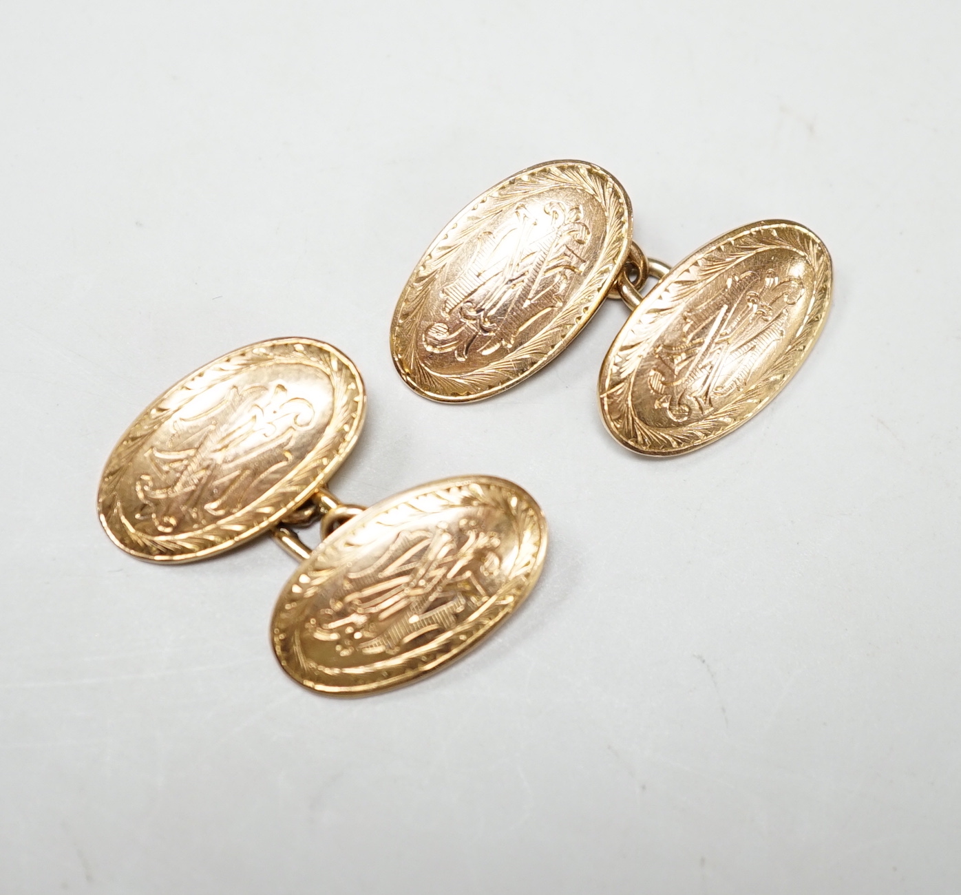 A pair of Edwardian engraved 15ct gold oval cufflinks, 10 grams.